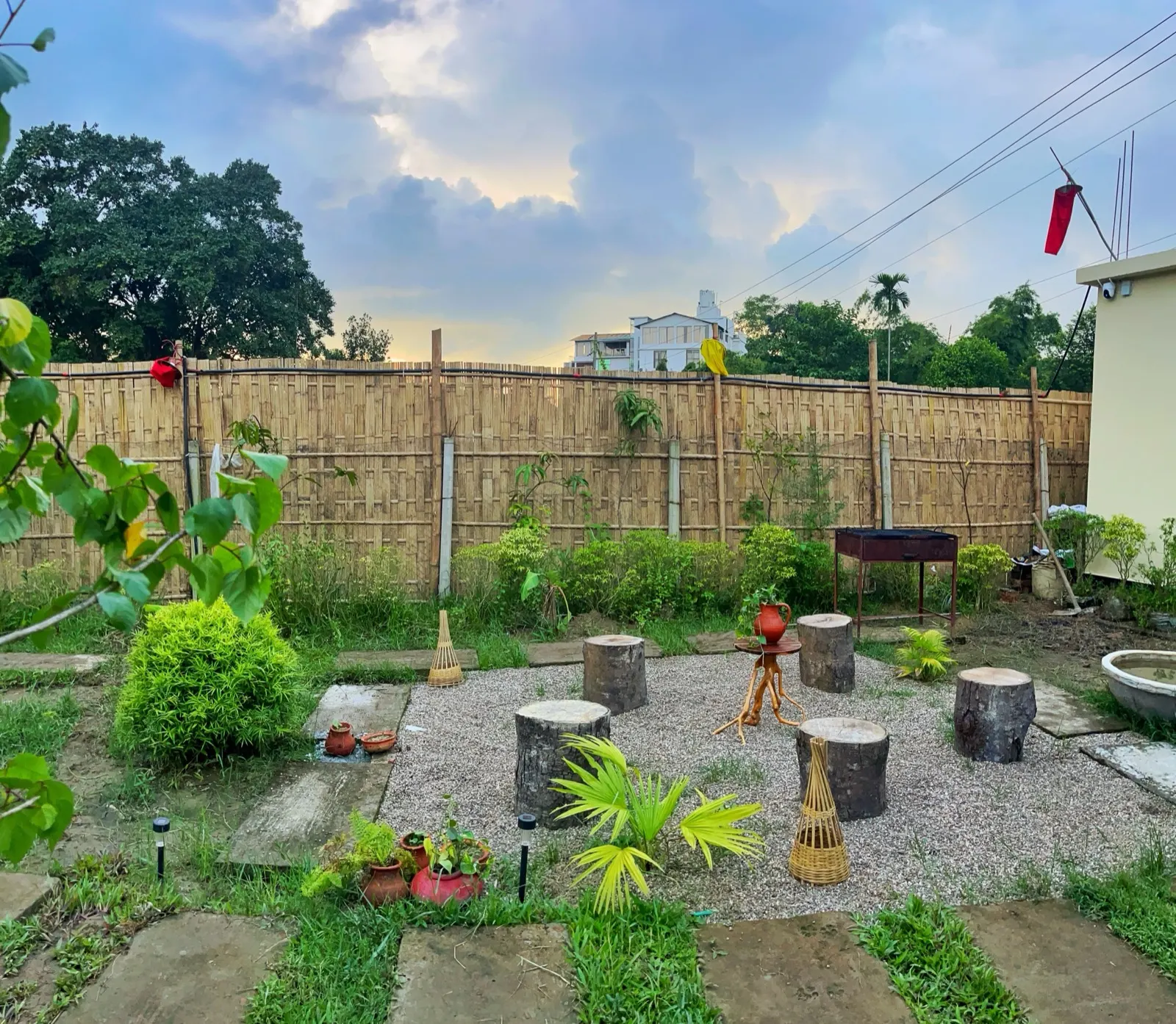 The gravel courtyard with tree-stump seats at sunset