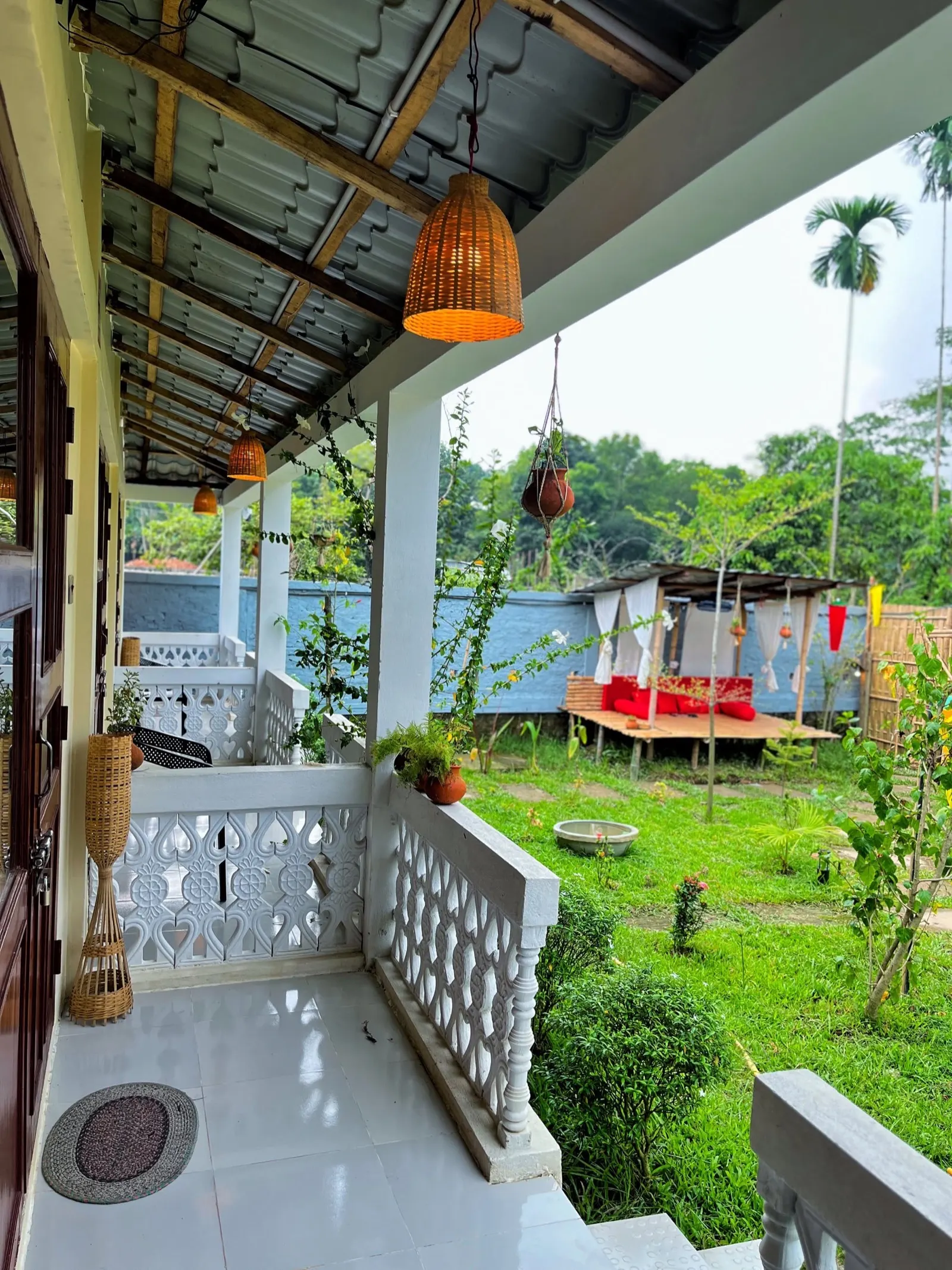 The veranda with hanging cane lamps, looking out over the garden