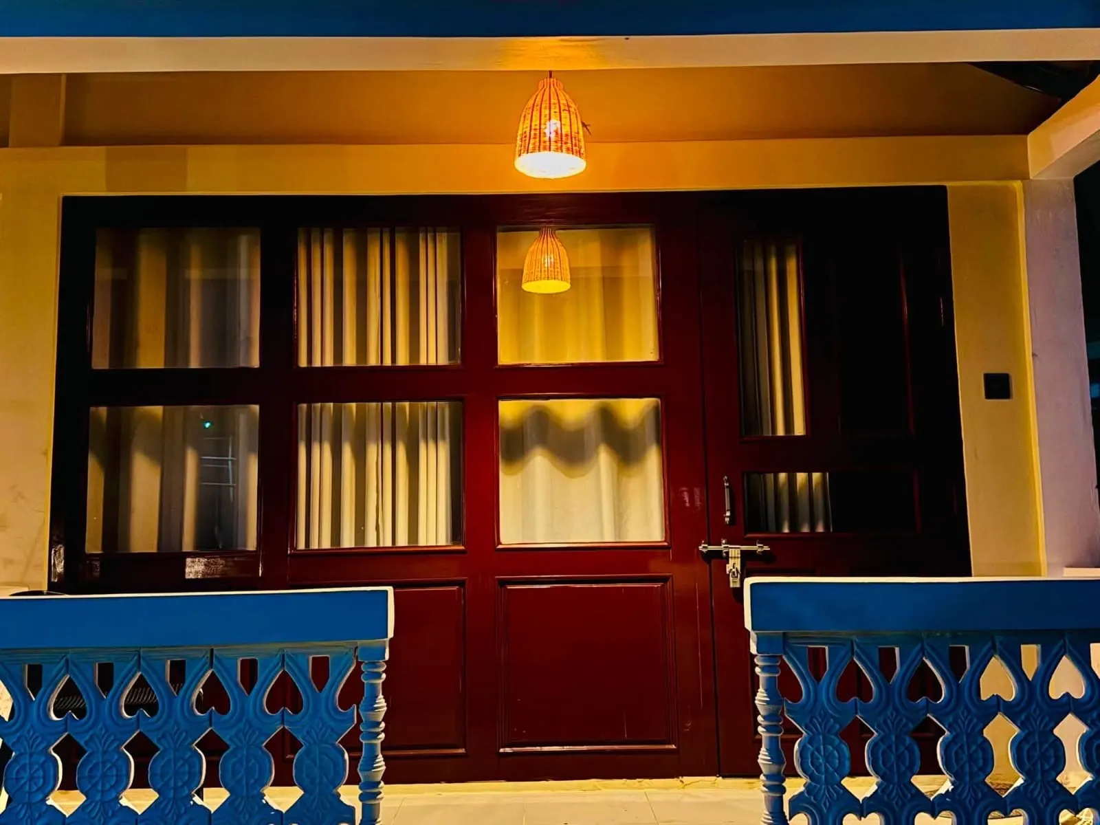 A room's glass doors under cane lamps at night